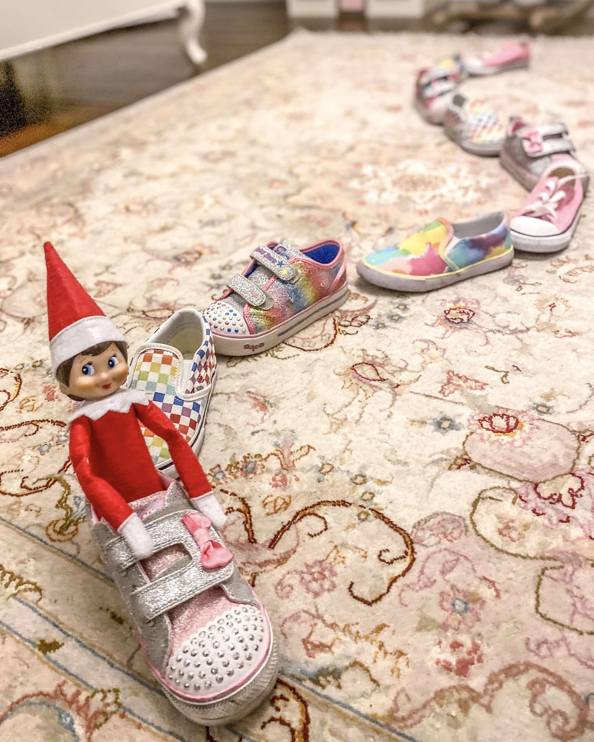 All aboard the Shoe-Shoe Train. Fun & easy Elf on the Shelf ideas for your toddler or little kid. Elf swinging on a roll of toilet paper. Quick to setup and lots of naughty and nice ideas, perfect to bring some Christmas magic to your home. #ElfOnTheShelf #ElfIdeas #ElfOnTheShelfIdeas #Christmas #ChristmasMagic