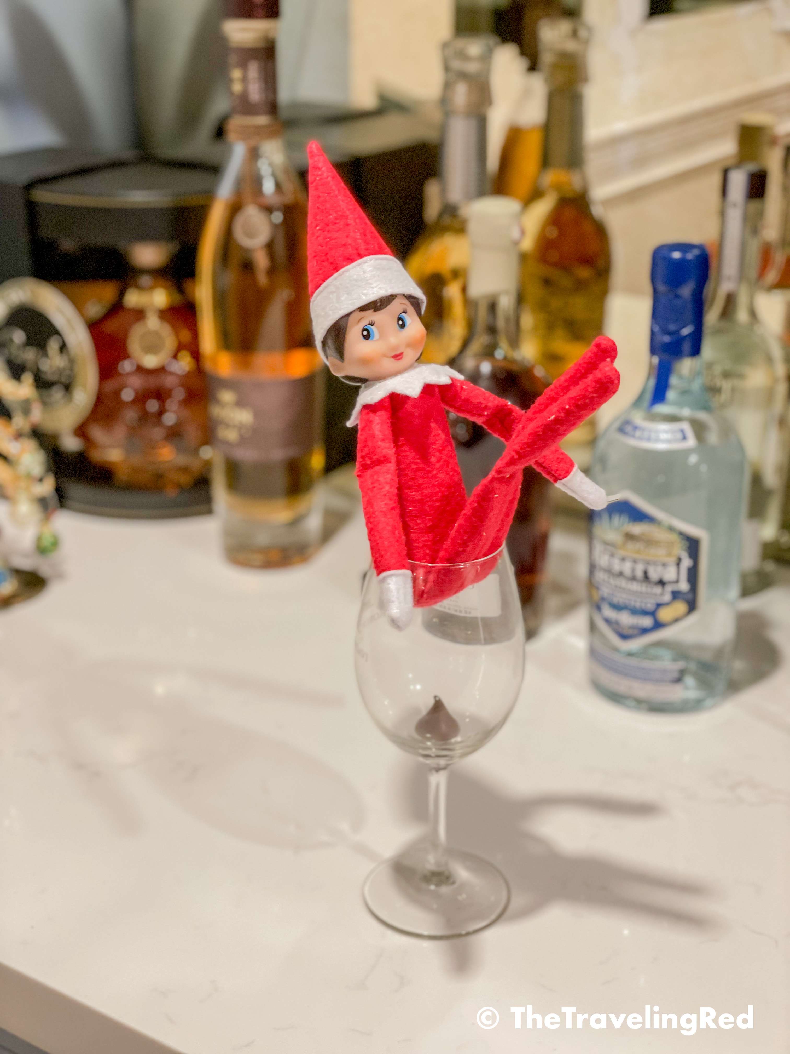 Naughty Elf on the shelf pooped a Hershey's kiss in a wine glass. Fun and easy elf on the shelf ideas for a naughty elf that are quick and easy using things you have at home.