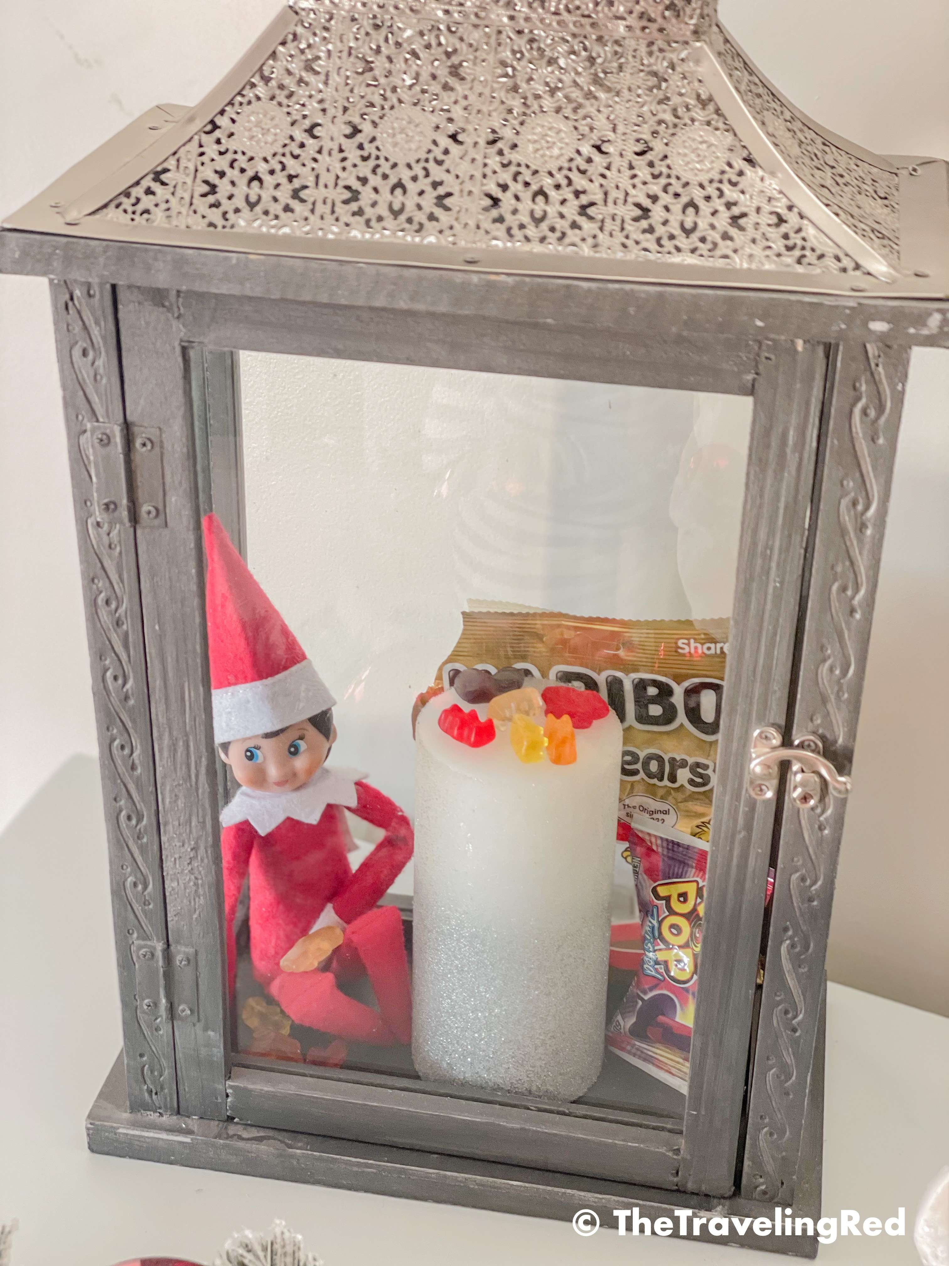 Naughty Elf on the shelf found some gummy bear candies and hid in a decorative lantern to eat them. Fun and easy elf on the shelf ideas for a naughty elf that are quick and easy using things you have at home.
