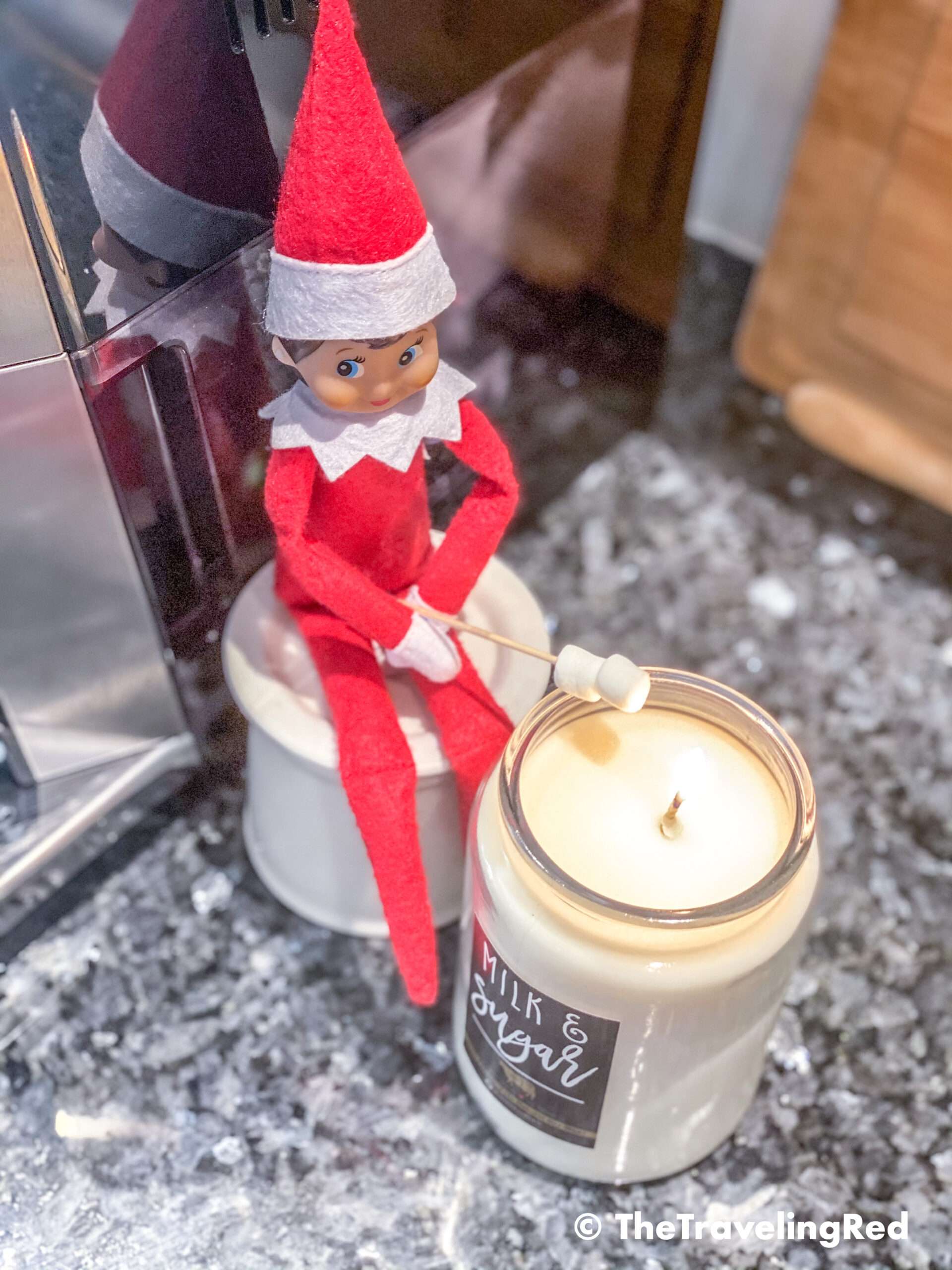 Naughty Elf on the shelf making s'mores using mini marshmallows and a candle. Fun and easy elf on the shelf ideas for a naughty elf that are quick and easy using things you have at home.